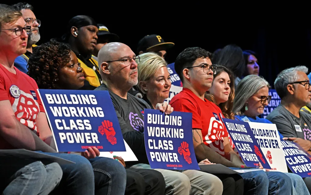 Attendees at a union rally holding signs that read "BUILDING WORKING CLASS POWER."