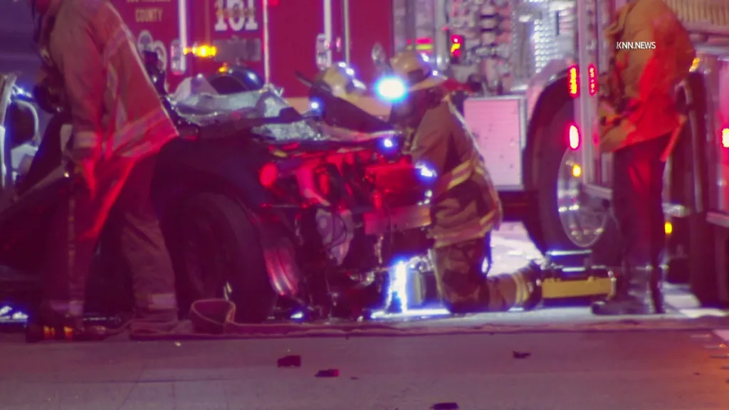 Firefighters tending to a wrecked car at a crash site on the 405 Freeway.