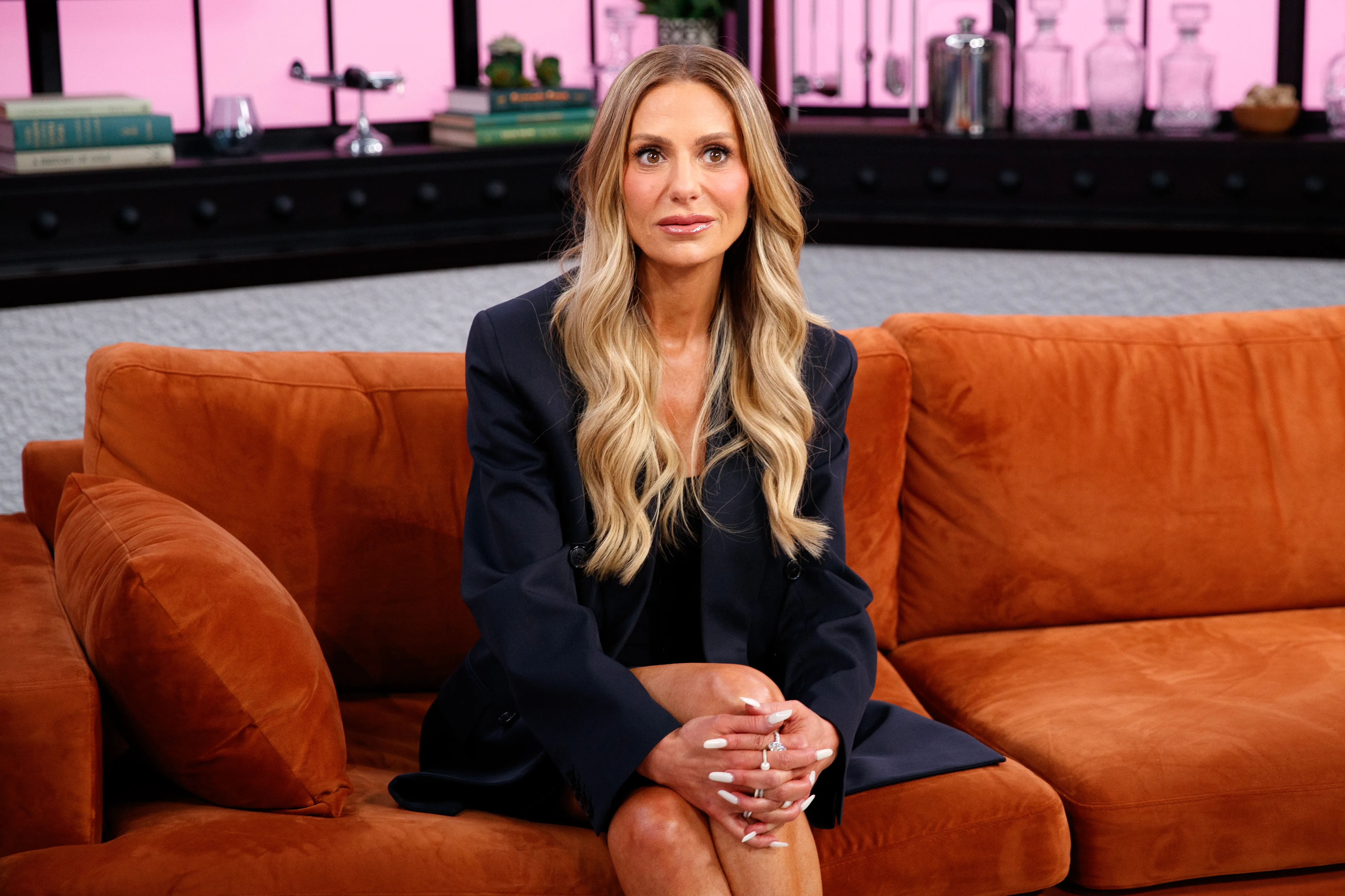 Dorit Kemsley sitting on an orange sofa during an interview.
