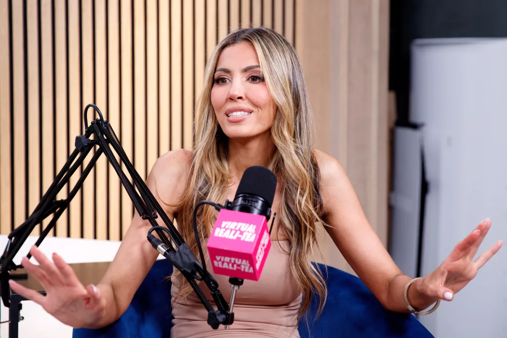 Georgina Ferzli speaking into a microphone with "Virtual Reali-Tea" branding.