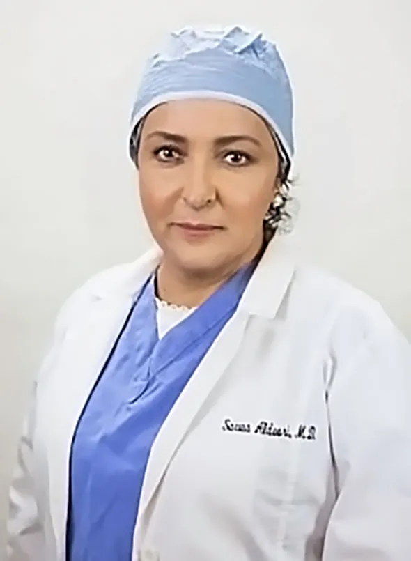 Sarwa Aldoori, a plastic surgeon, wearing a scrub cap and lab coat.