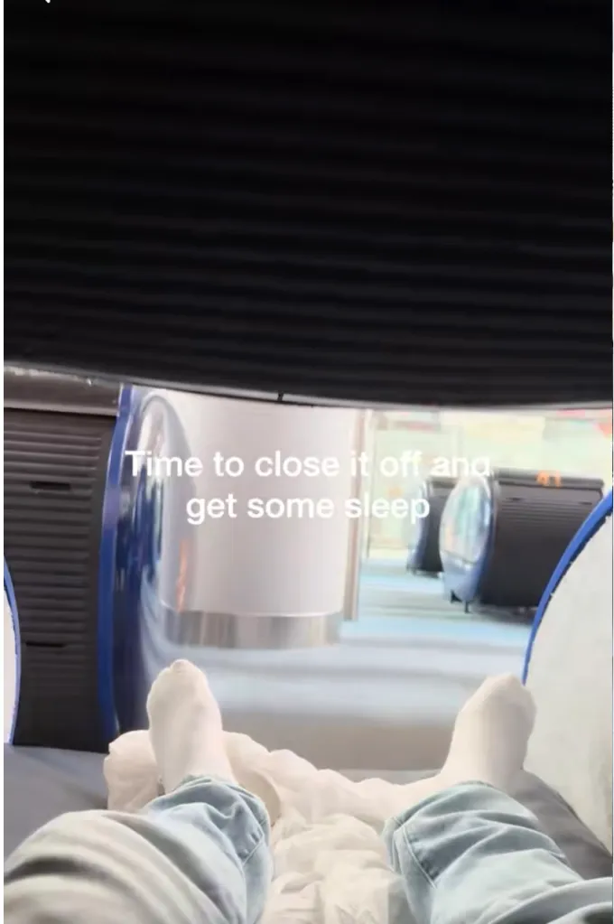 A person's legs and feet inside a sleep pod with the text