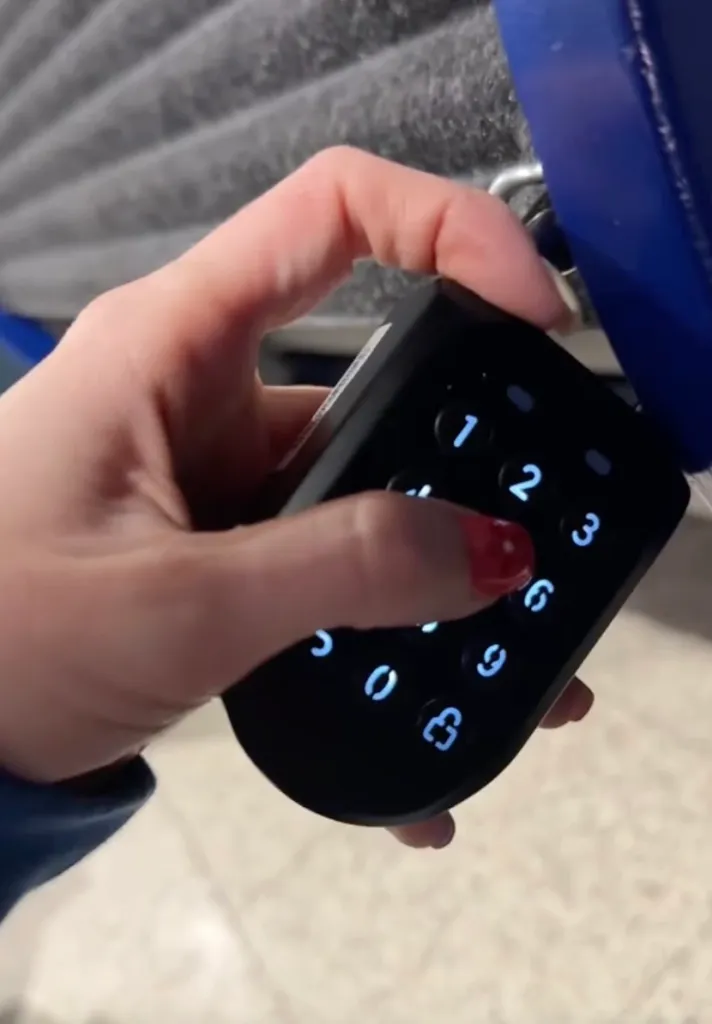 A hand entering a code on a digital keypad for a sleep pod.
