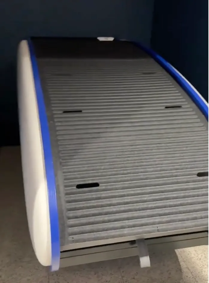 A close-up shot of a white and blue sleep pod with a ribbed gray interior.
