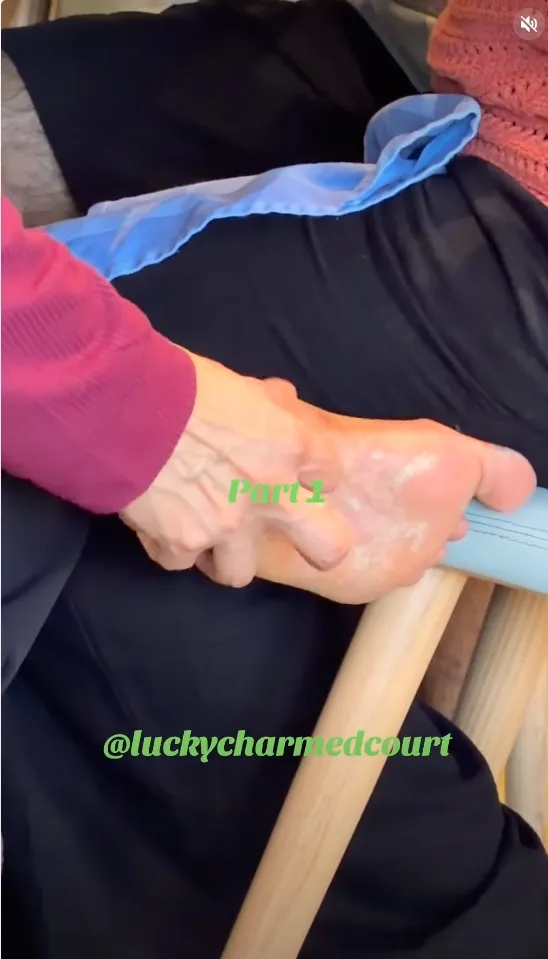 A person using their fingers to scrape something off the bottom of their foot.