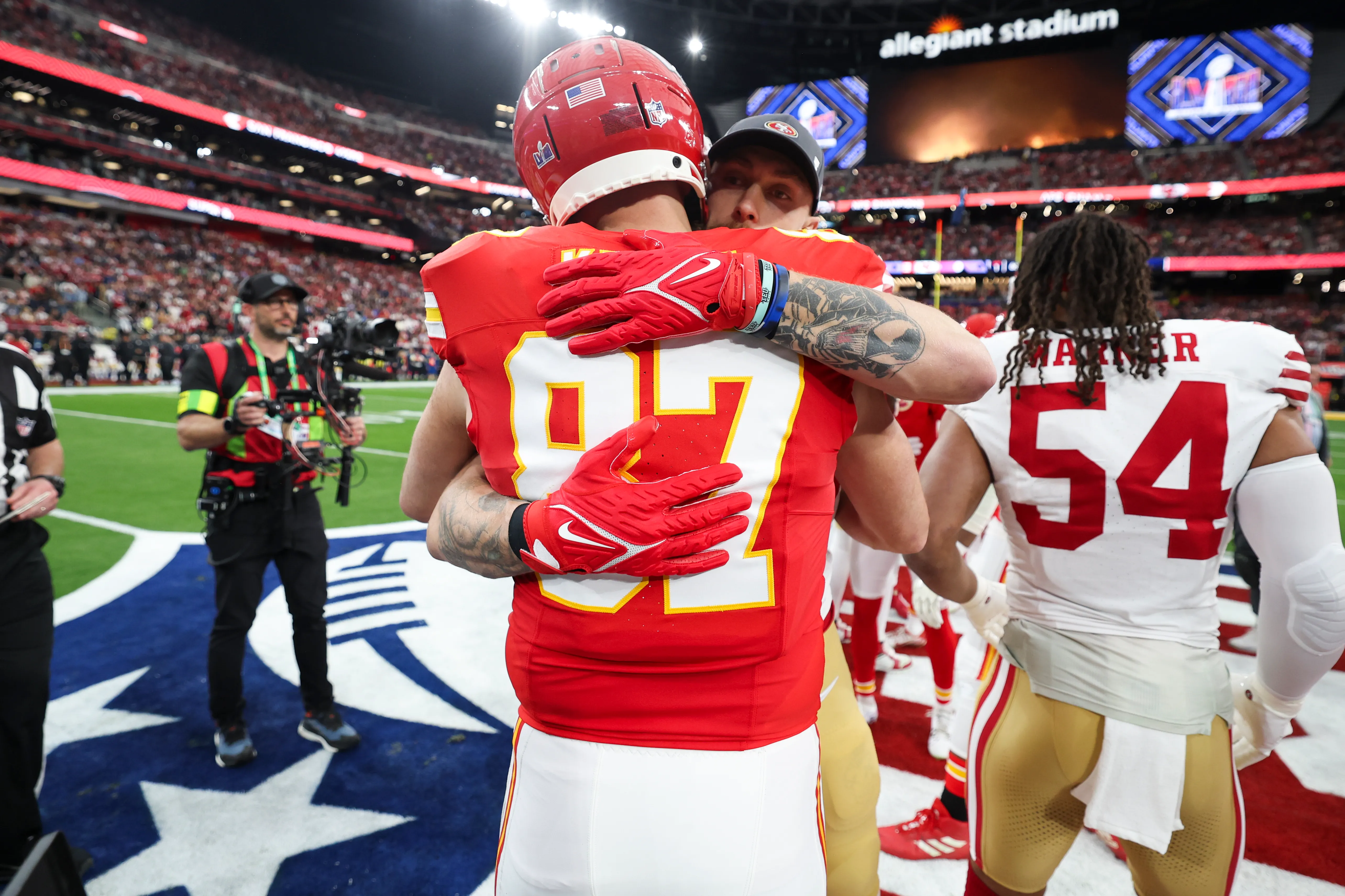 Travis Kelce and George Kittle embrace before Super Bowl LVIII.