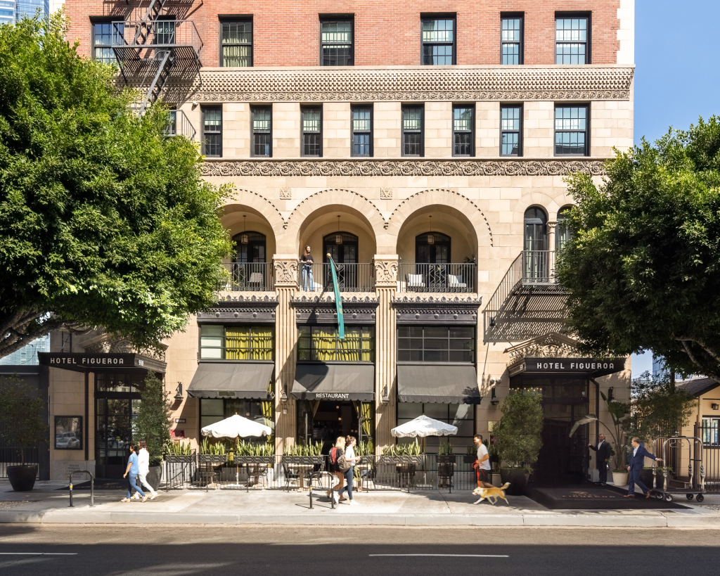 Exterior of Hotel Figueroa with people walking by.
