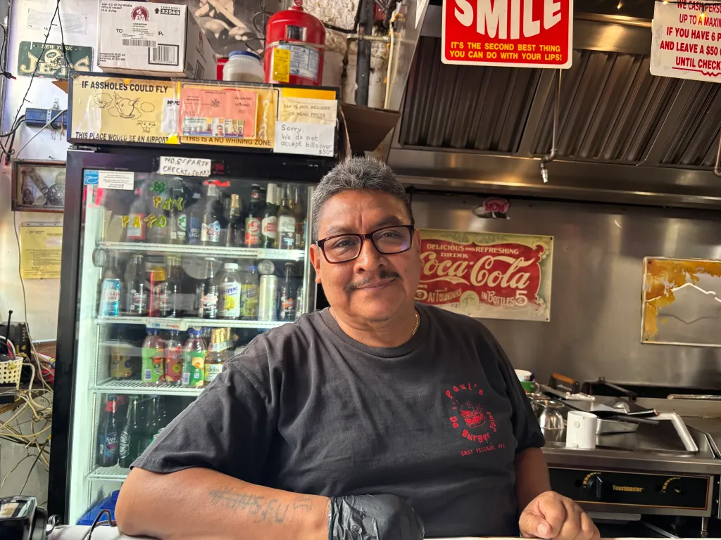 Jose Amigon smiling at the camera in a restaurant.