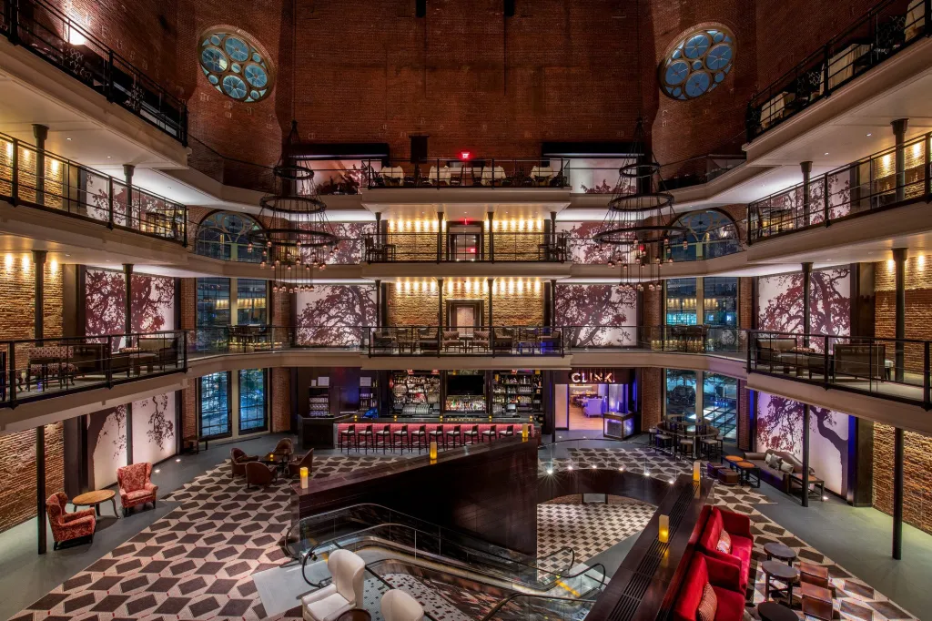 Lobby of the Liberty Hotel, with a central bar on the ground floor and multiple levels of balconies overlooking it.