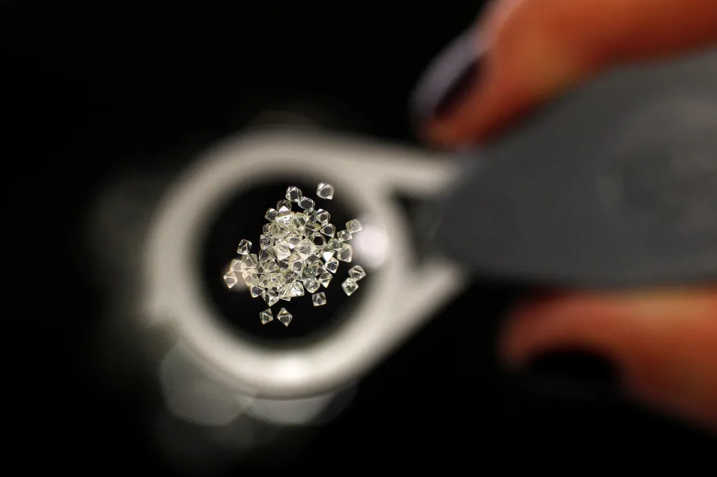 Uncut diamonds from Southern Africa and Canada viewed through a jeweler's loupe.