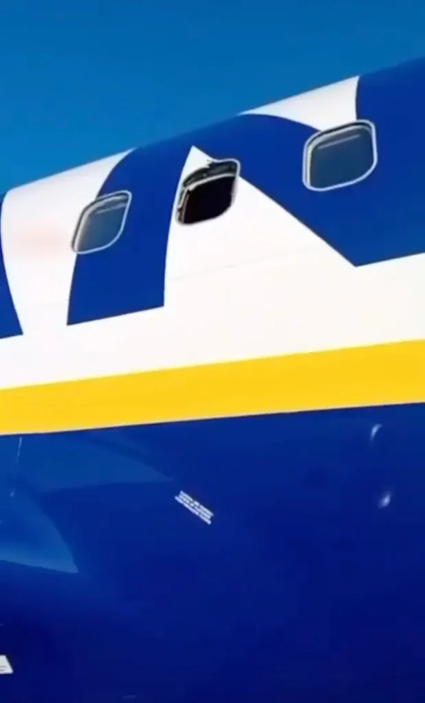 Close-up of an airplane fuselage with a white and blue livery and a yellow stripe.