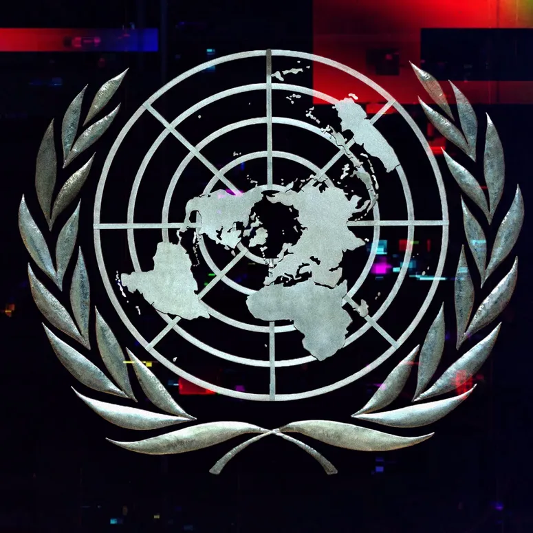 A photo illustration of the United Nations symbol with a glitch effect overlaying it.