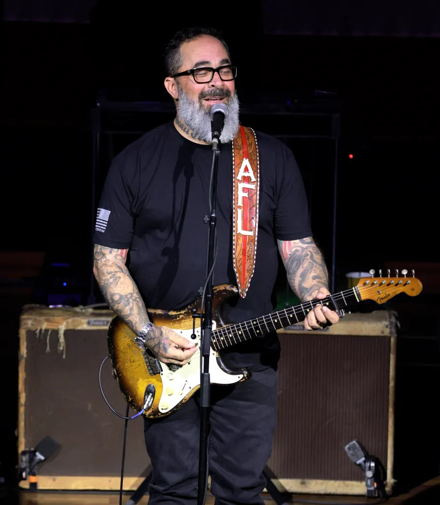 Aaron Lewis performing live on stage while playing an electric guitar.