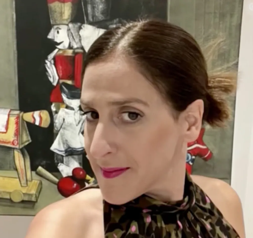 Nadia Michelidaki, the accused mother, looks at the camera while standing in front of a painting of toy soldiers.