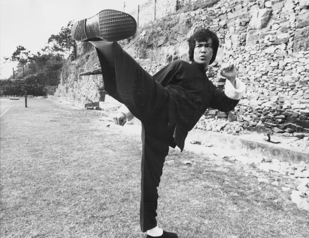 Bruce Lee performing a high kick on the set of "Enter the Dragon".