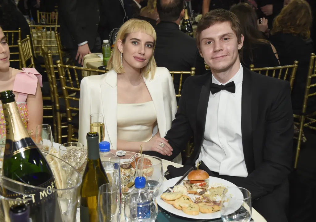 Emma Roberts and Evan Peters seated at a table at the Critics' Choice Awards.