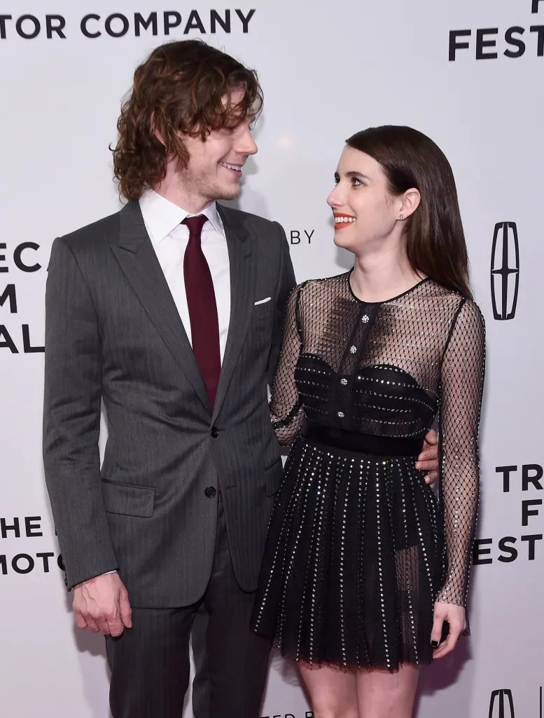 Actors Evan Peters and Emma Roberts looking at each other at the "Dabka" Premiere.