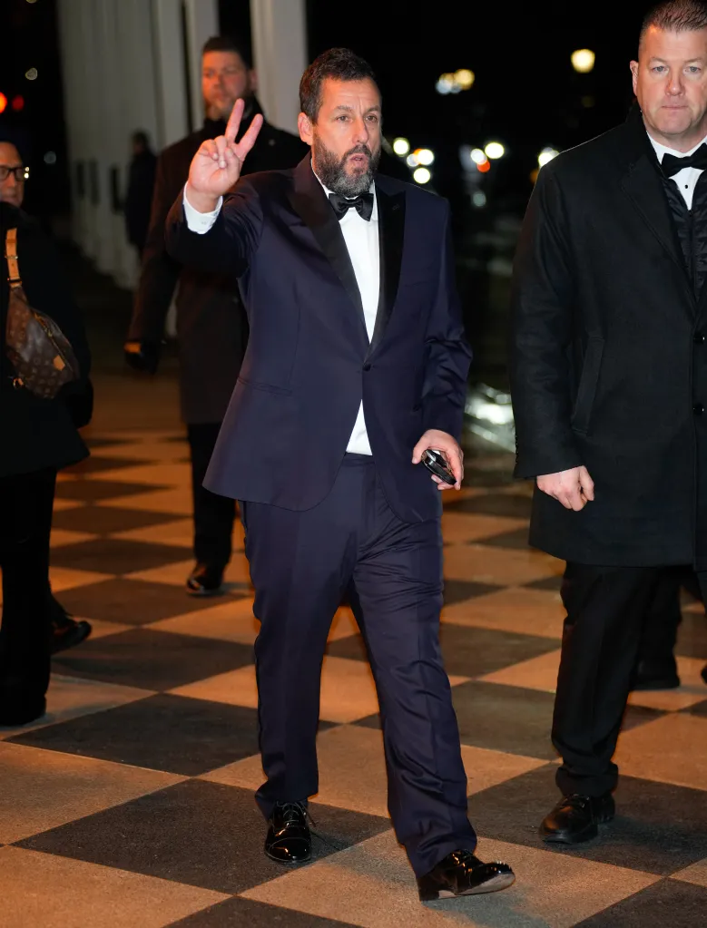 Adam Sandler giving a peace sign while attending the SNL50 afterparty.