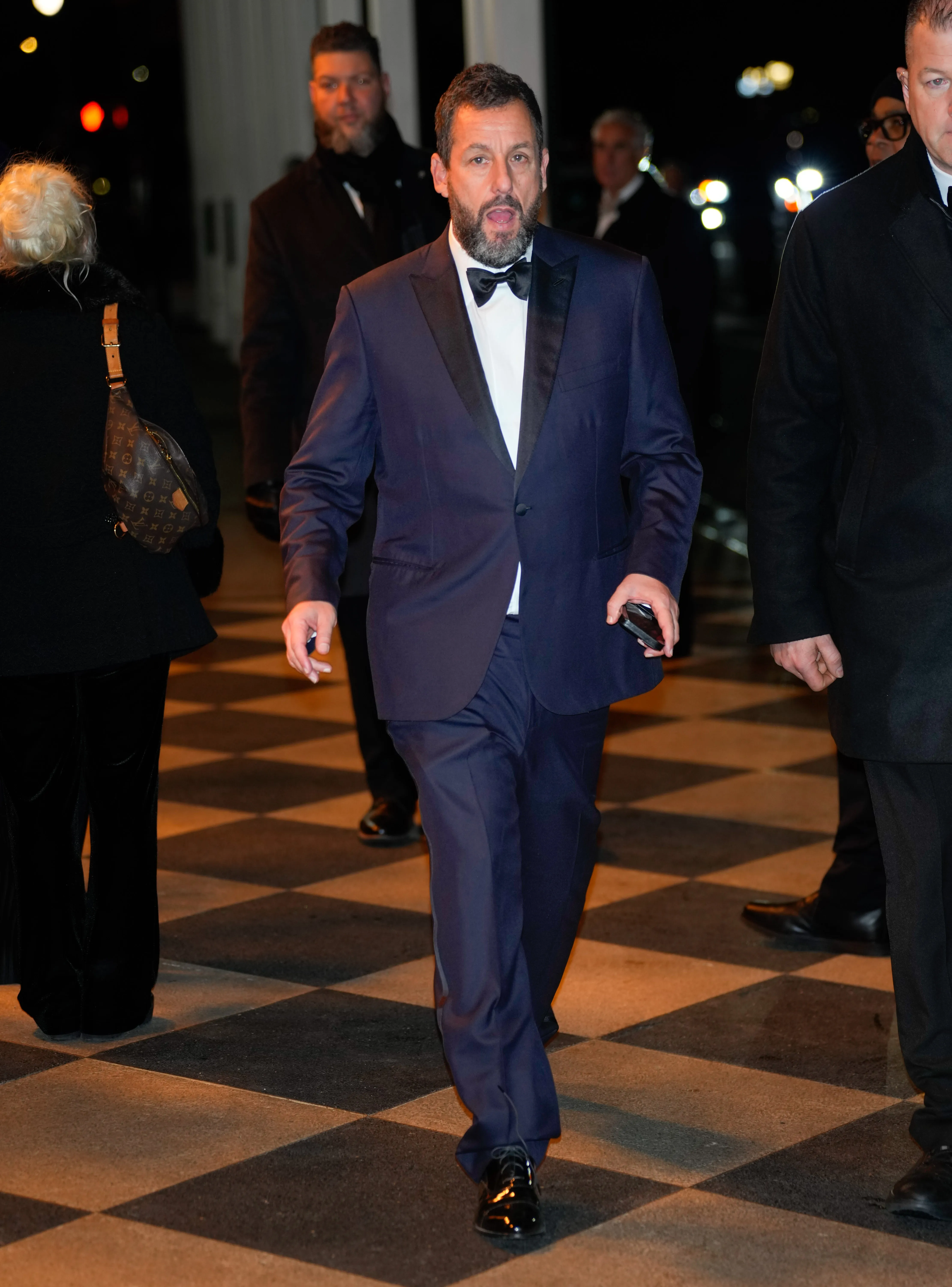 Adam Sandler in a tuxedo at an SNL afterparty.