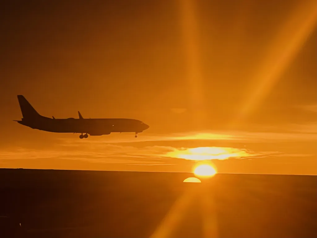 Airplane landing at Denver International Airport at sunrise.