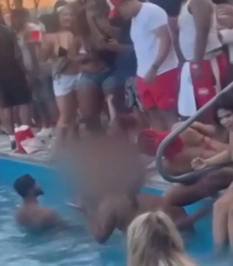 People gathered around and in a pool at a crowded party.