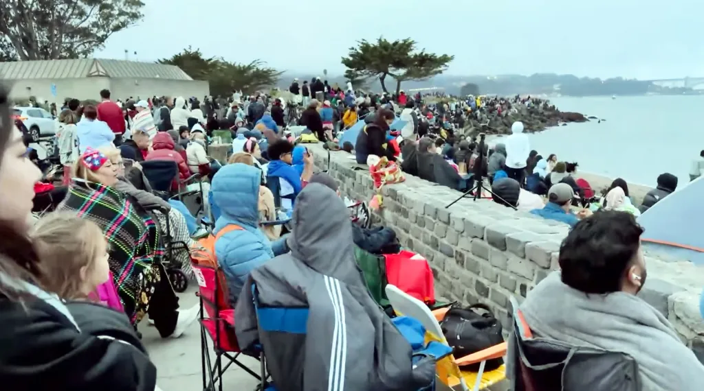 People gathered by the water for an Independence Day fireworks celebration.