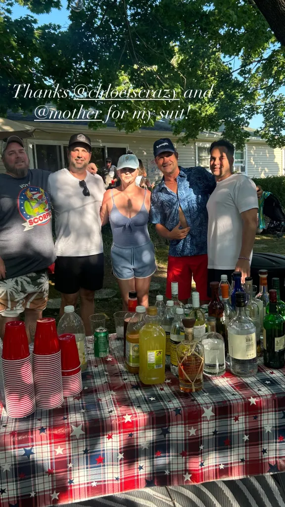 Amy Schumer in swimwear with friends around a table with drinks for the 4th of July.