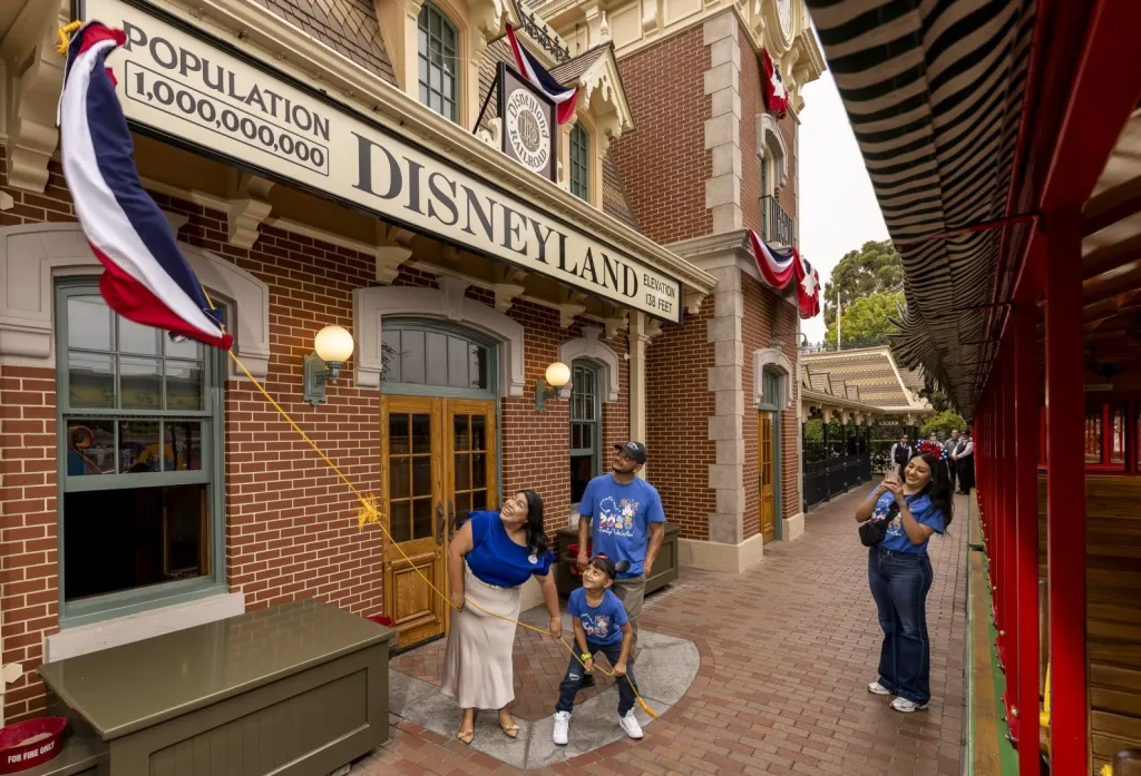Andres Robles and his family celebrating his 8th birthday at Disneyland, where a banner proclaims a population of “1,000,000,000.”