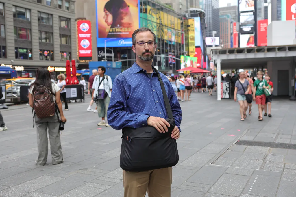 Andrew S. holding a bag in Times Square, NYC.