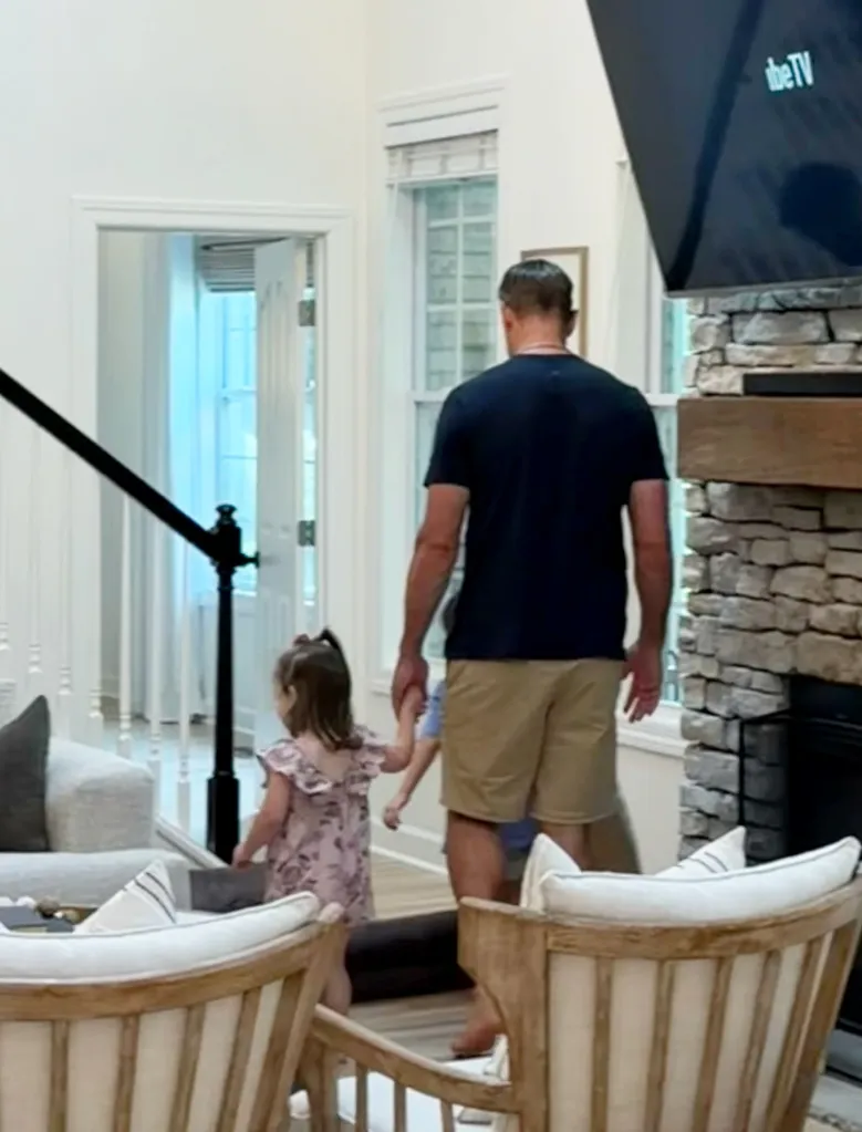 Aaron Rodgers holding a child's hand while walking.