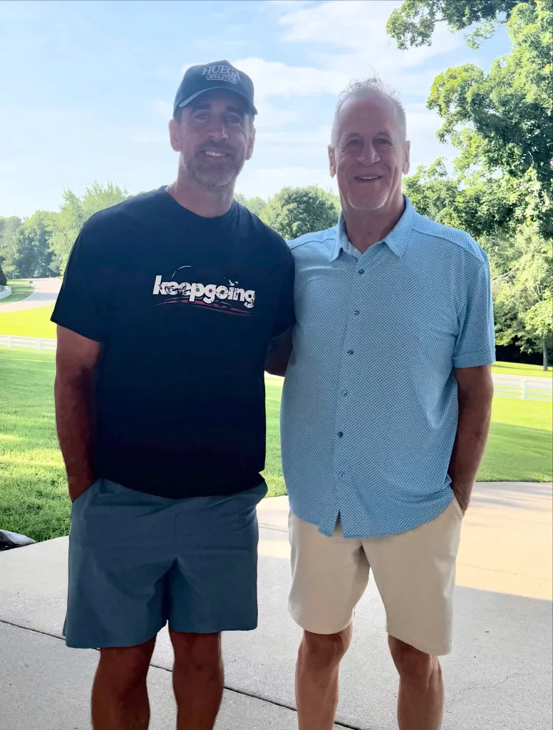 Aaron Rodgers and his father, Edward Rodgers, smiling at the camera outdoors.