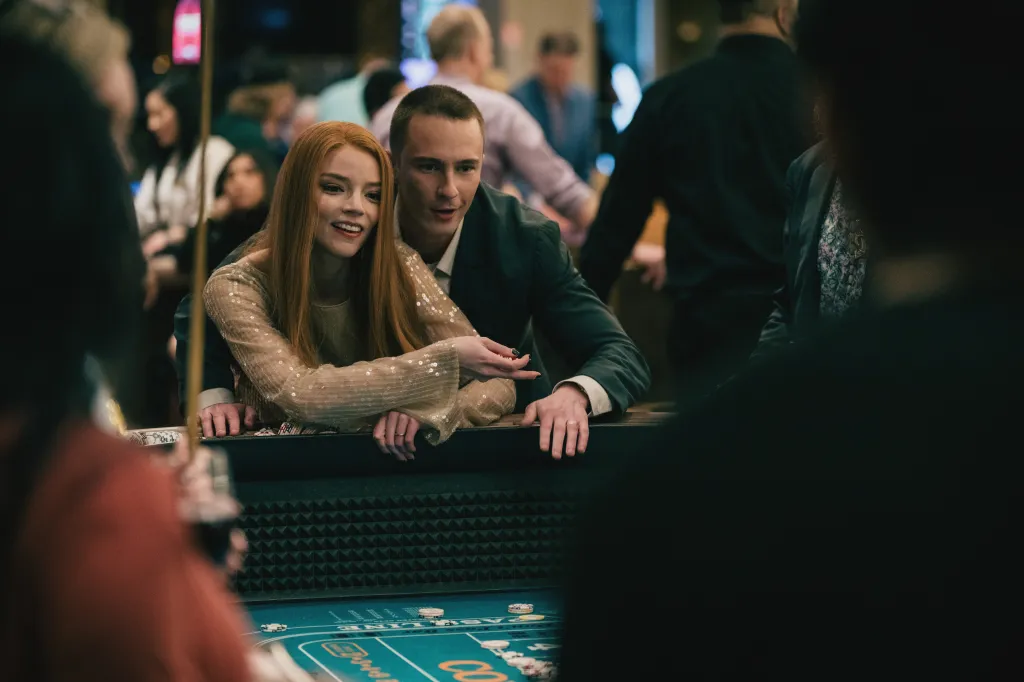 Anya Taylor-Joy and a man playing at a casino table.