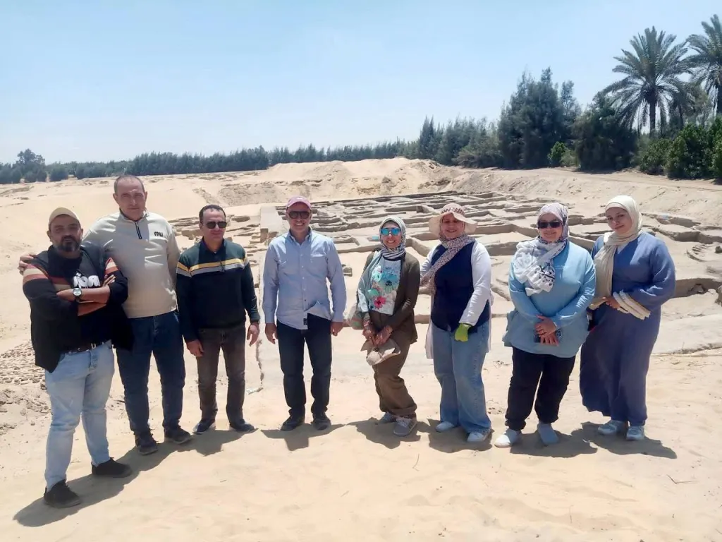 Archaeologists standing at the ancient settlement found at the Tell el-Koua site in the Wadi Tumilat region.