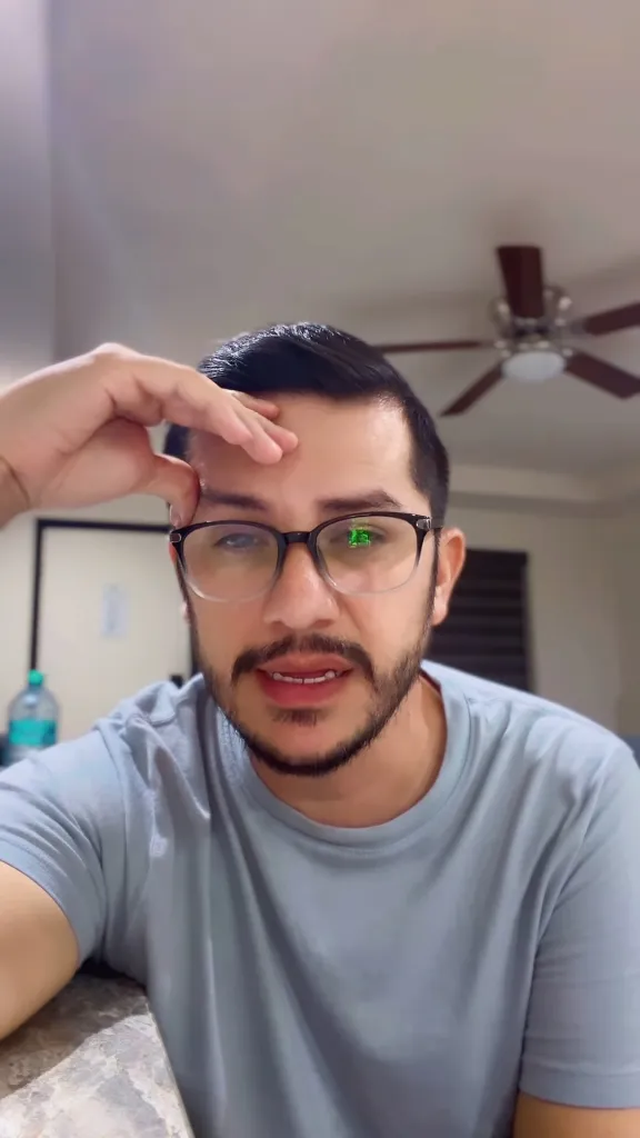 Armando Niedermeier-Rubio in a light blue shirt with one hand on his forehead.