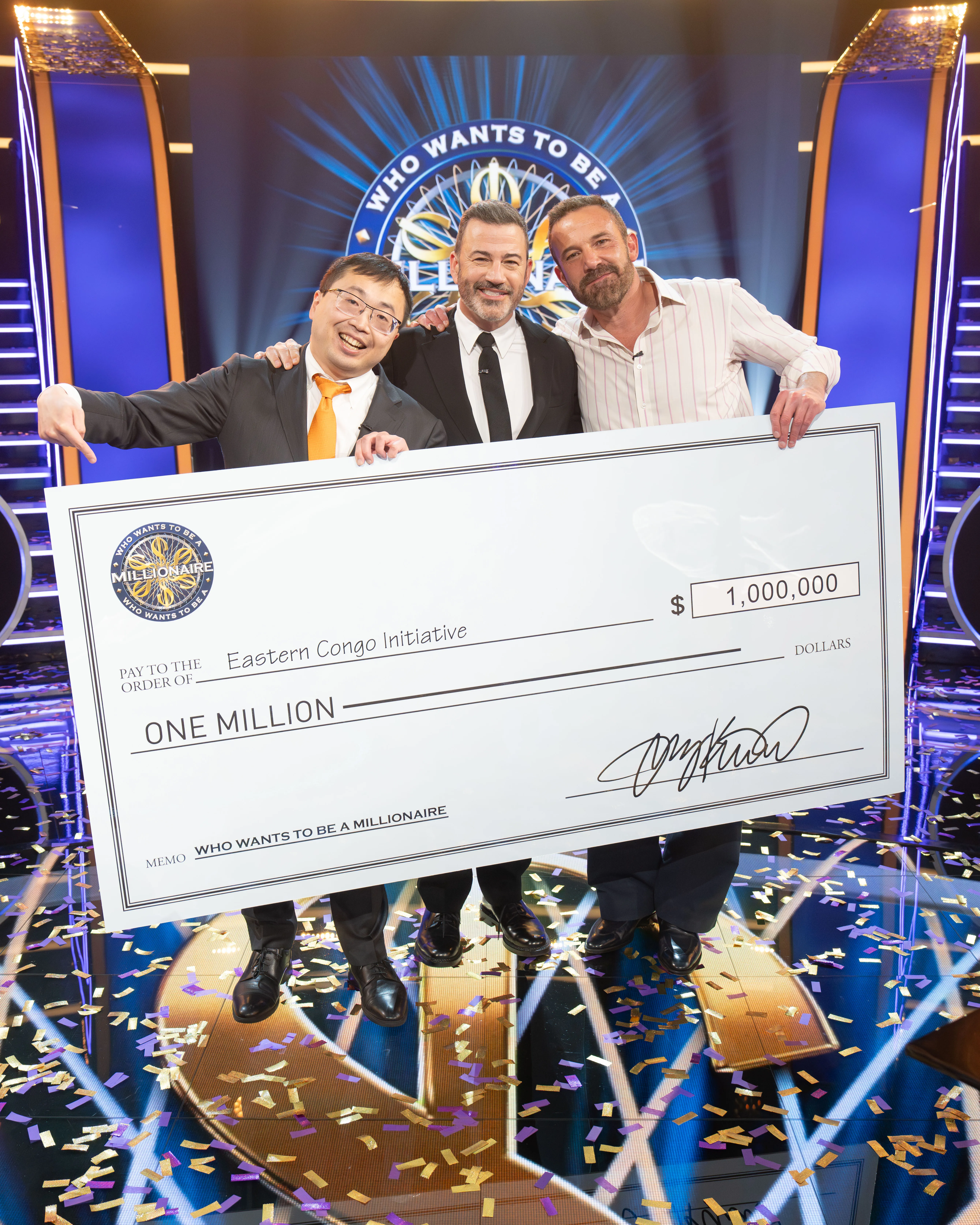 Jamie Ding, Jimmy Kimmel, and Ben Affleck holding a giant check for one million dollars for the Eastern Congo Initiative.