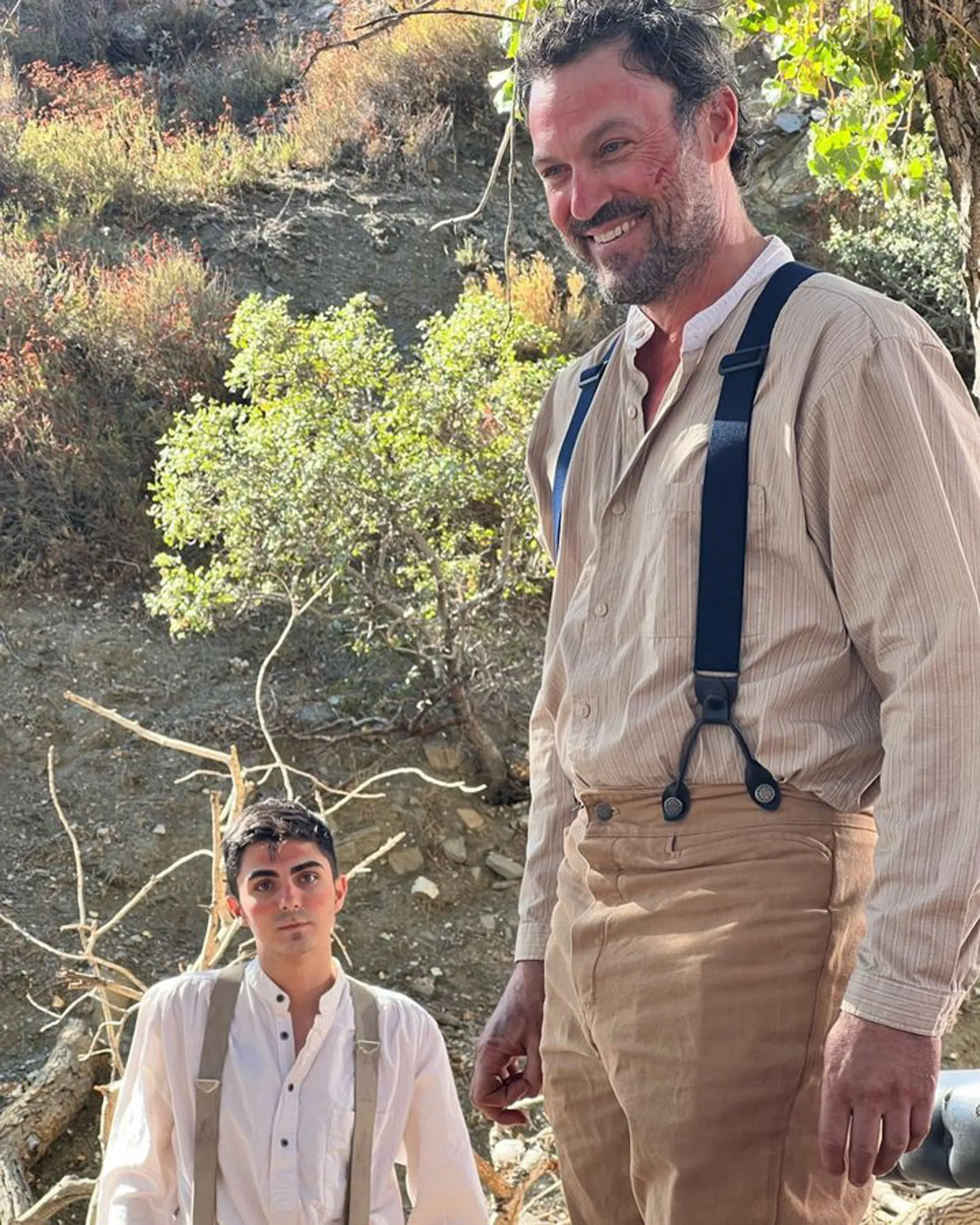 Brian Austin Green and another man in period clothing on a hillside.