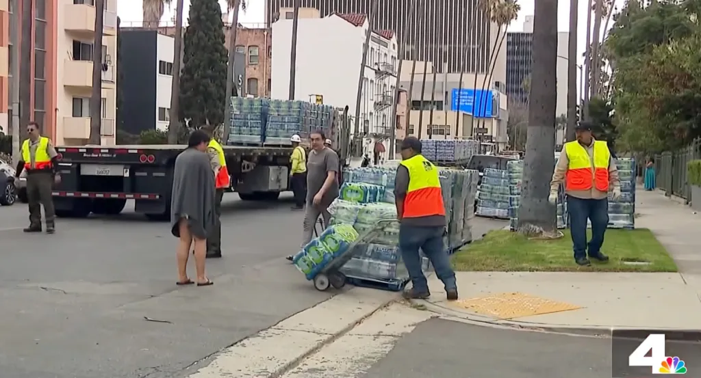 Workers distribute bottled water in Koreatown following an E.coli contamination scare.