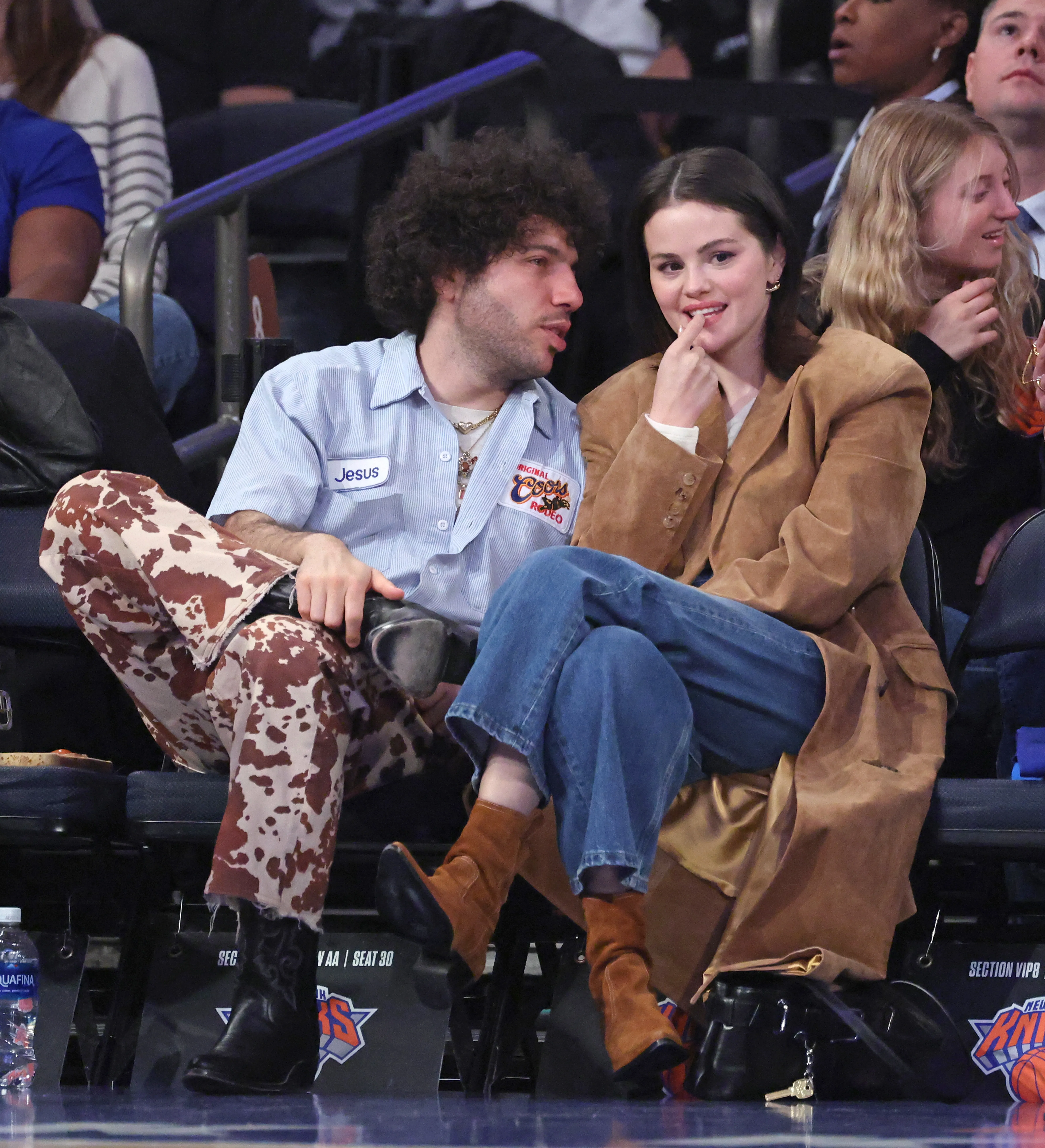 Selena Gomez and Benny Blanco seated courtside during a Boston Celtics vs. New York Knicks game.