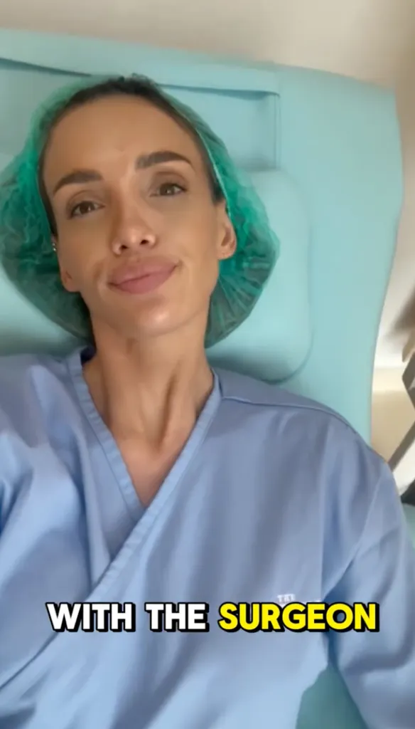 A woman wearing a surgical cap and gown sits in a medical chair.