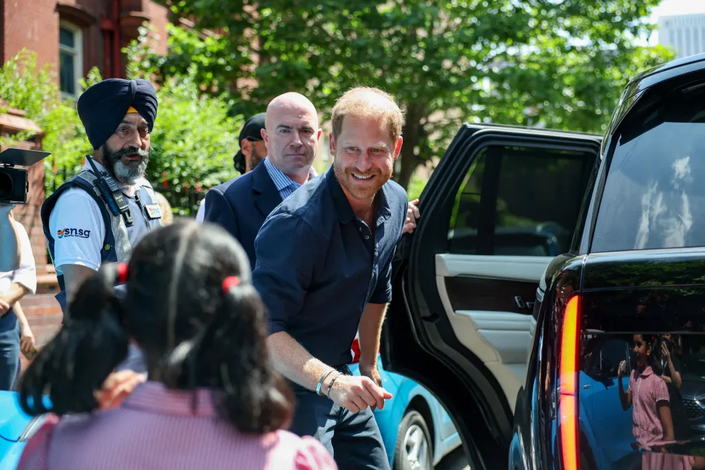 Prince Harry greets a child outside Birmingham Children's Hospital.