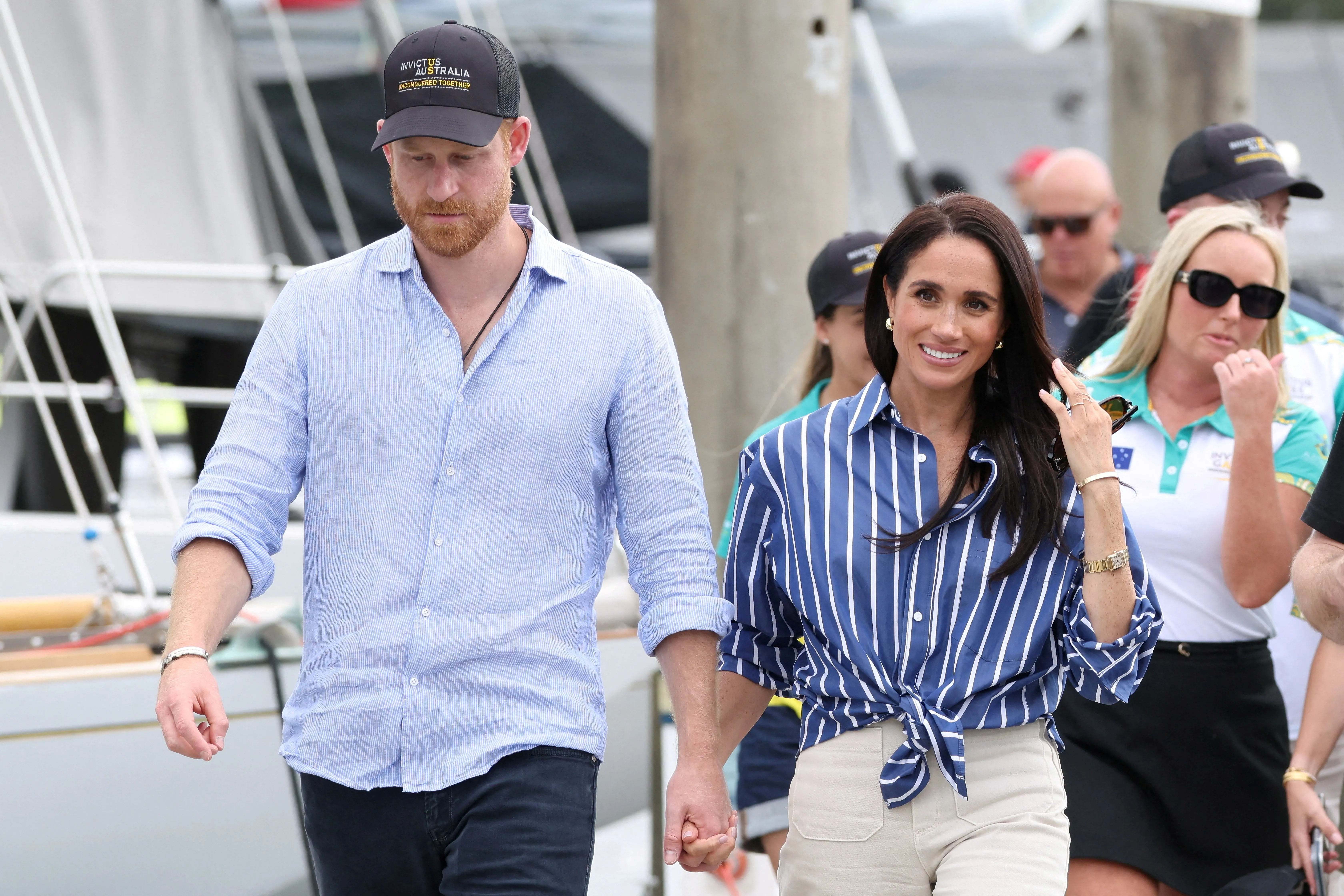 Prince Harry and Meghan Markle holding hands while walking through Sydney, Australia.