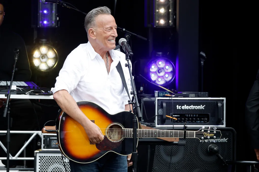 Bruce Springsteen performing with an acoustic guitar at the dedication ceremony for the Barack Obama Presidential Center.