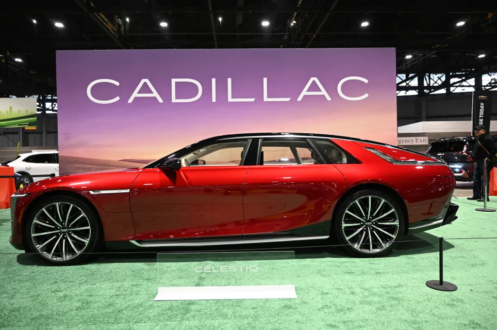 A red Cadillac CELESTIQ ultra-luxury electric sedan on display at an auto show.