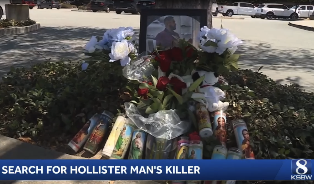 A memorial with a framed photo of Javier Becerril, white and red flowers, and religious candles.