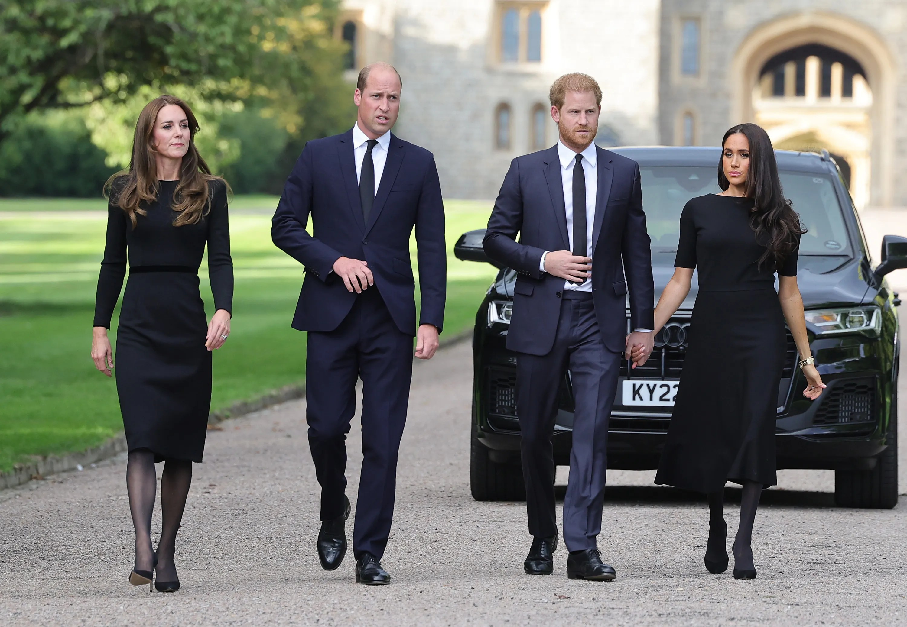 Catherine, Princess of Wales, Prince William, Prince of Wales, Prince Harry, Duke of Sussex, and Meghan, Duchess of Sussex walking together outside Windsor Castle.