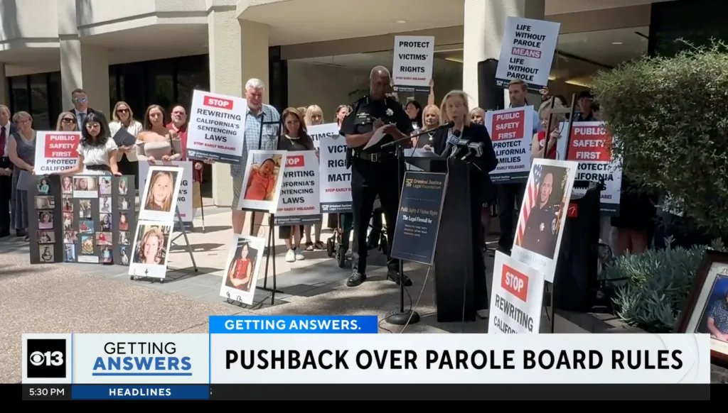 Protestors hold signs and photos of victims to oppose new parole regulations for violent offenders.