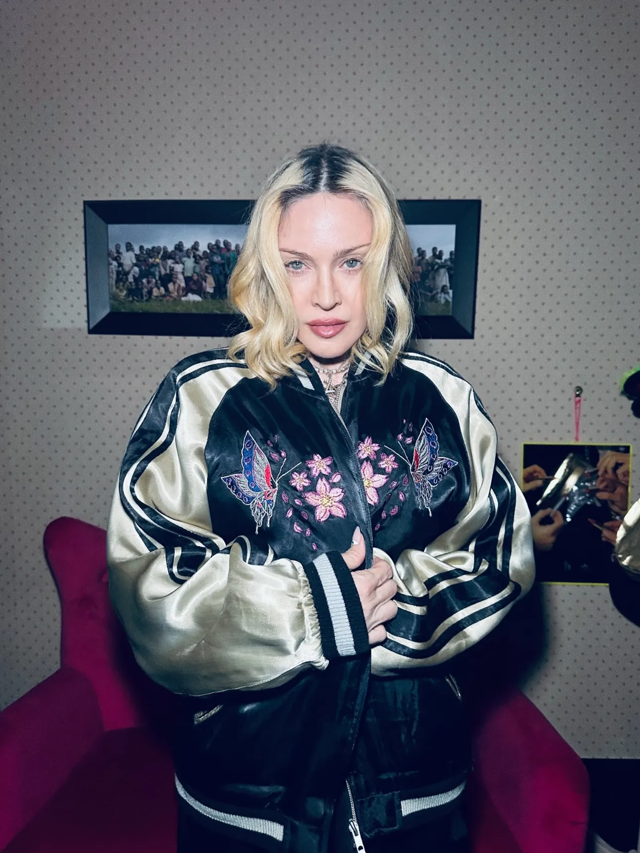 Madonna wearing a satin bomber jacket with embroidered butterflies and cherry blossoms.