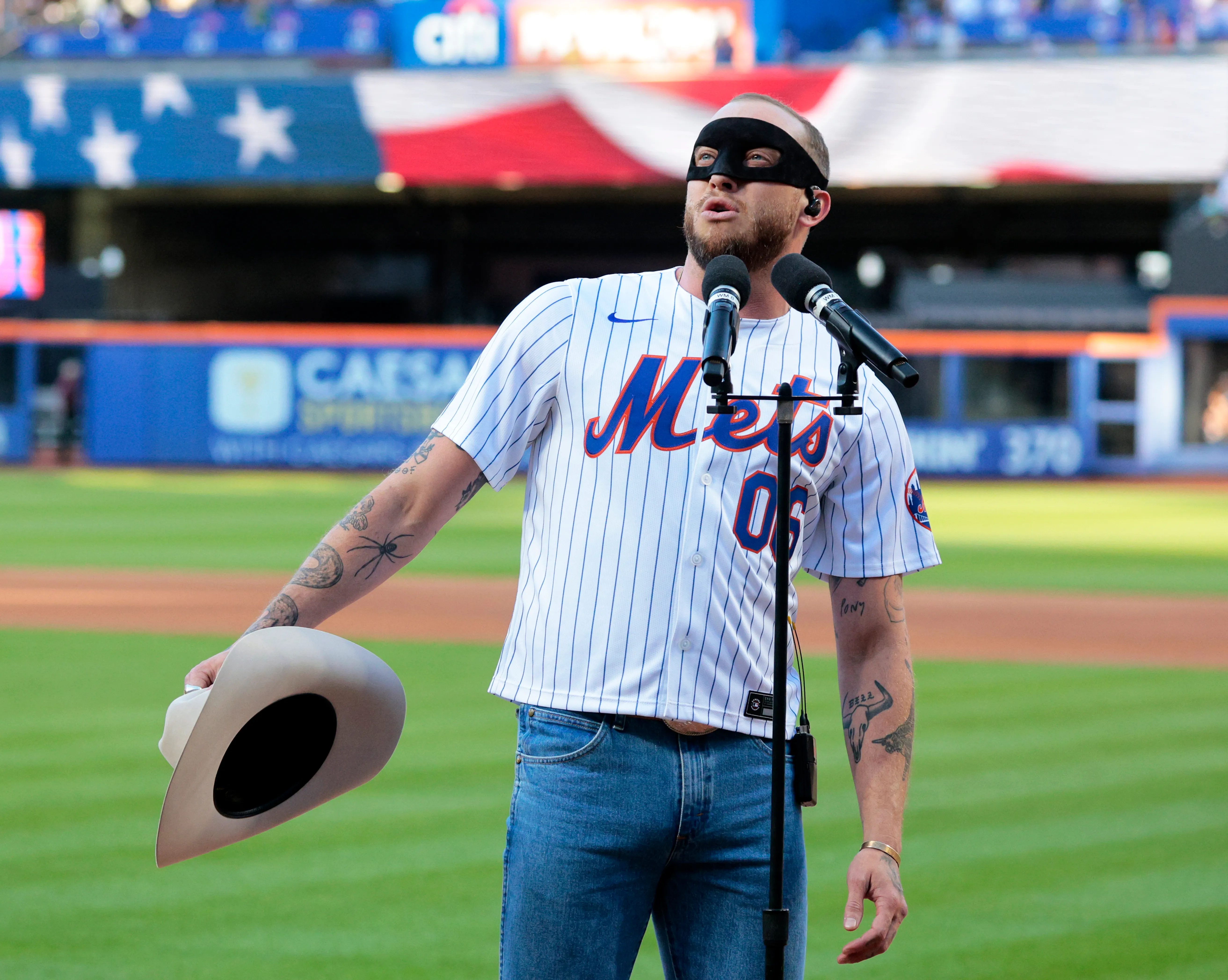Country music singer Orville Peck singing the National Anthem at a baseball game.