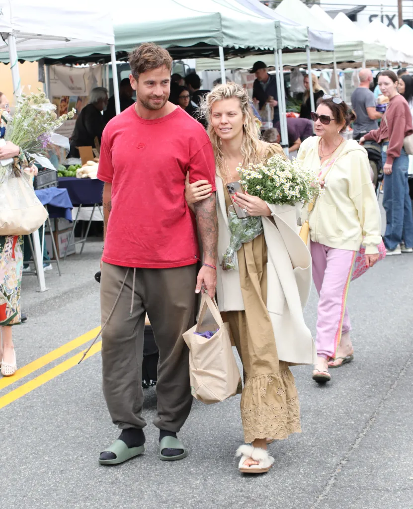 Danny Cipriani and AnnaLynne McCord walk arm in arm at a market.