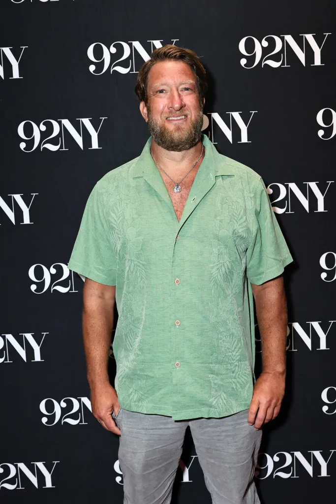 Dave Portnoy, with a beard and light green shirt, standing in front of a black background with "92NY" logos.